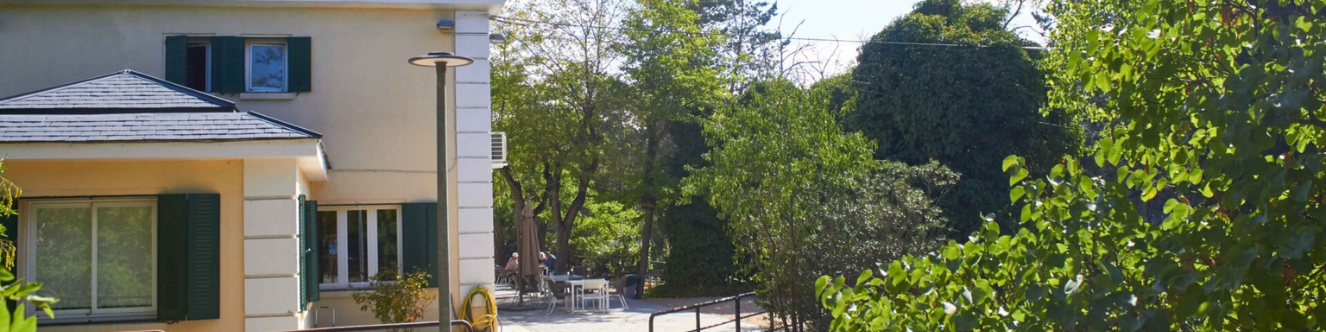 Casa como de campo a la izquierda con jardines al frente y derecha
