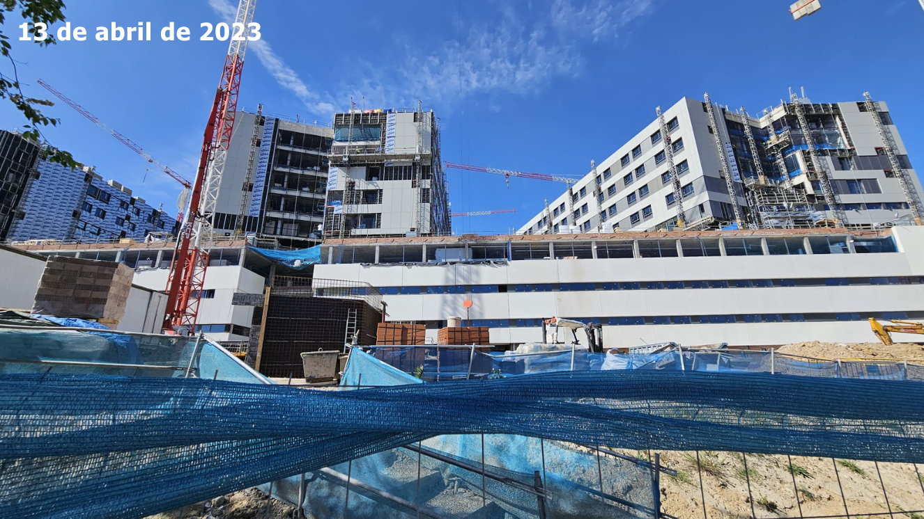 obras edificios vistos de abajo a arriba y al fondo con redes azules en primer plano