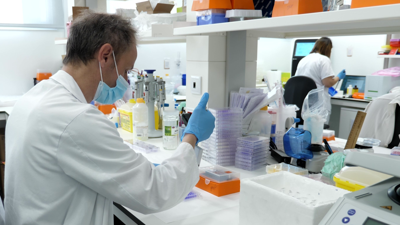 hombre con bata blanca con pipeta en laboratorio