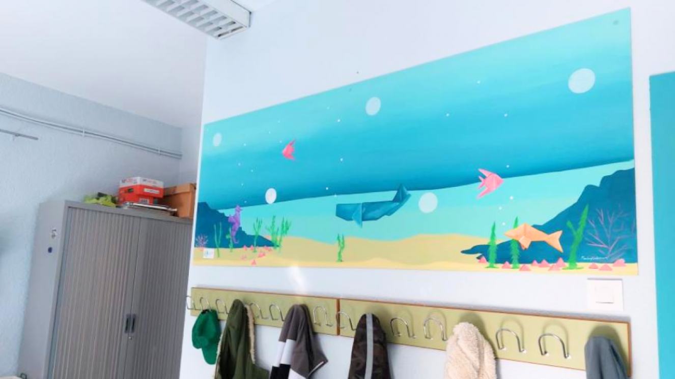 paisaje de playa pintado en pared sobre perchero de aula 