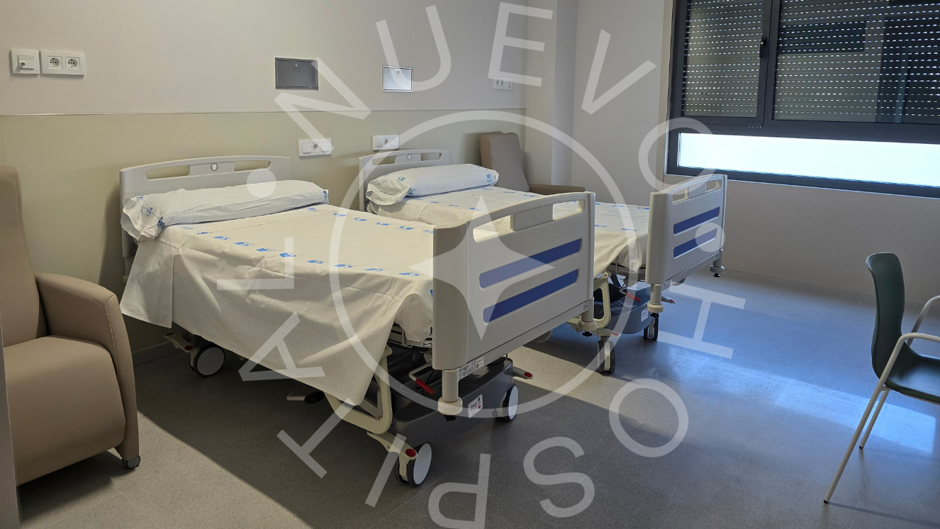 habitación de hospital con sillón color café a la derecha y cama en el centro y otra detrás y a la izquierda se ve la parte trasera de una silla