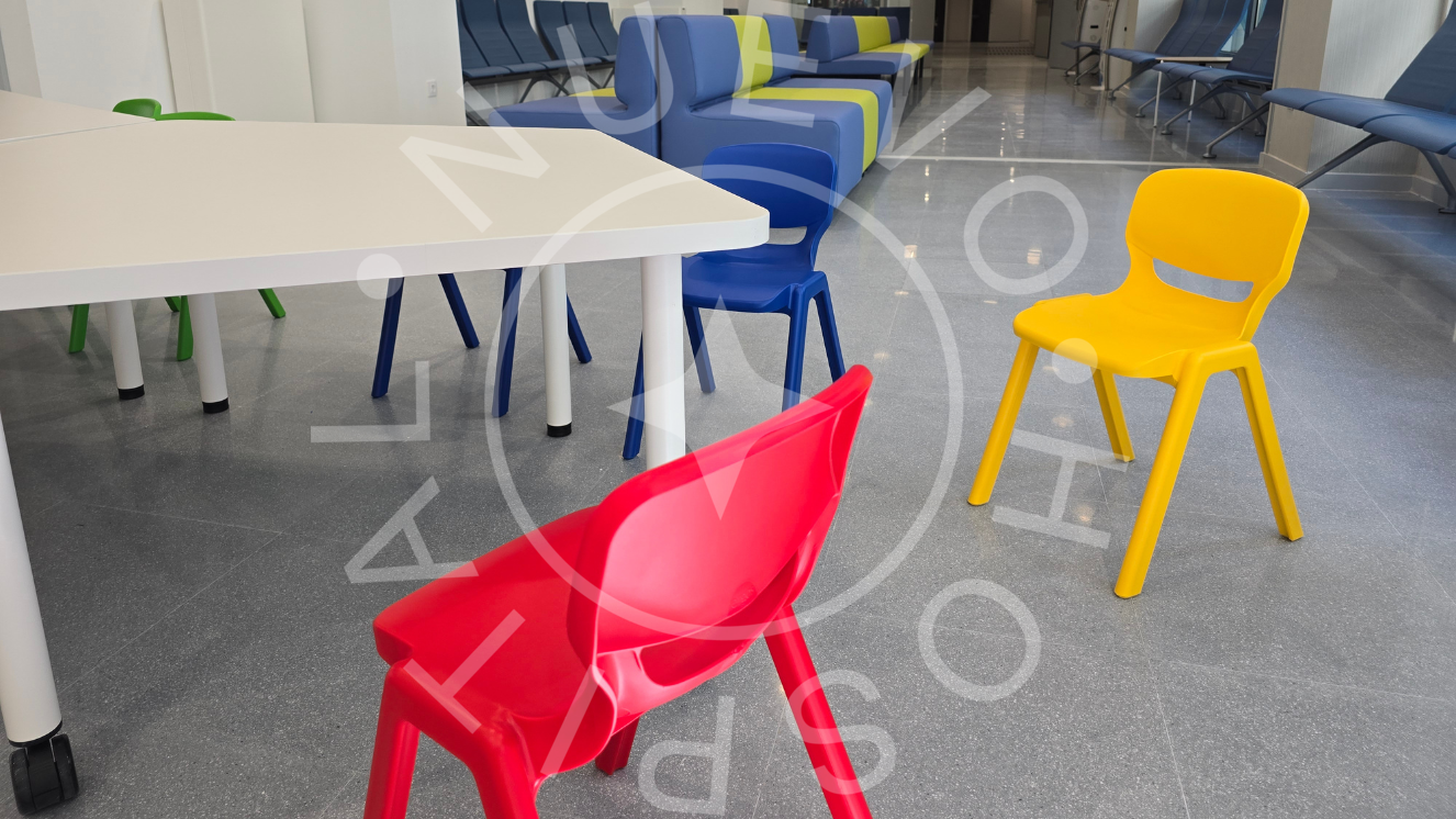 Sillas pequeñas roja, azul y amarilla con mesa blanca