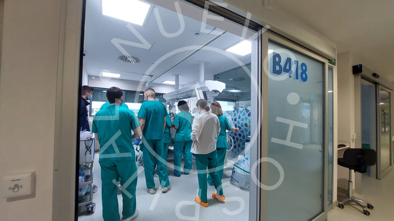 Box de Cuidados Críticos con profesionales dentro foto desde afuera con puerta abierta