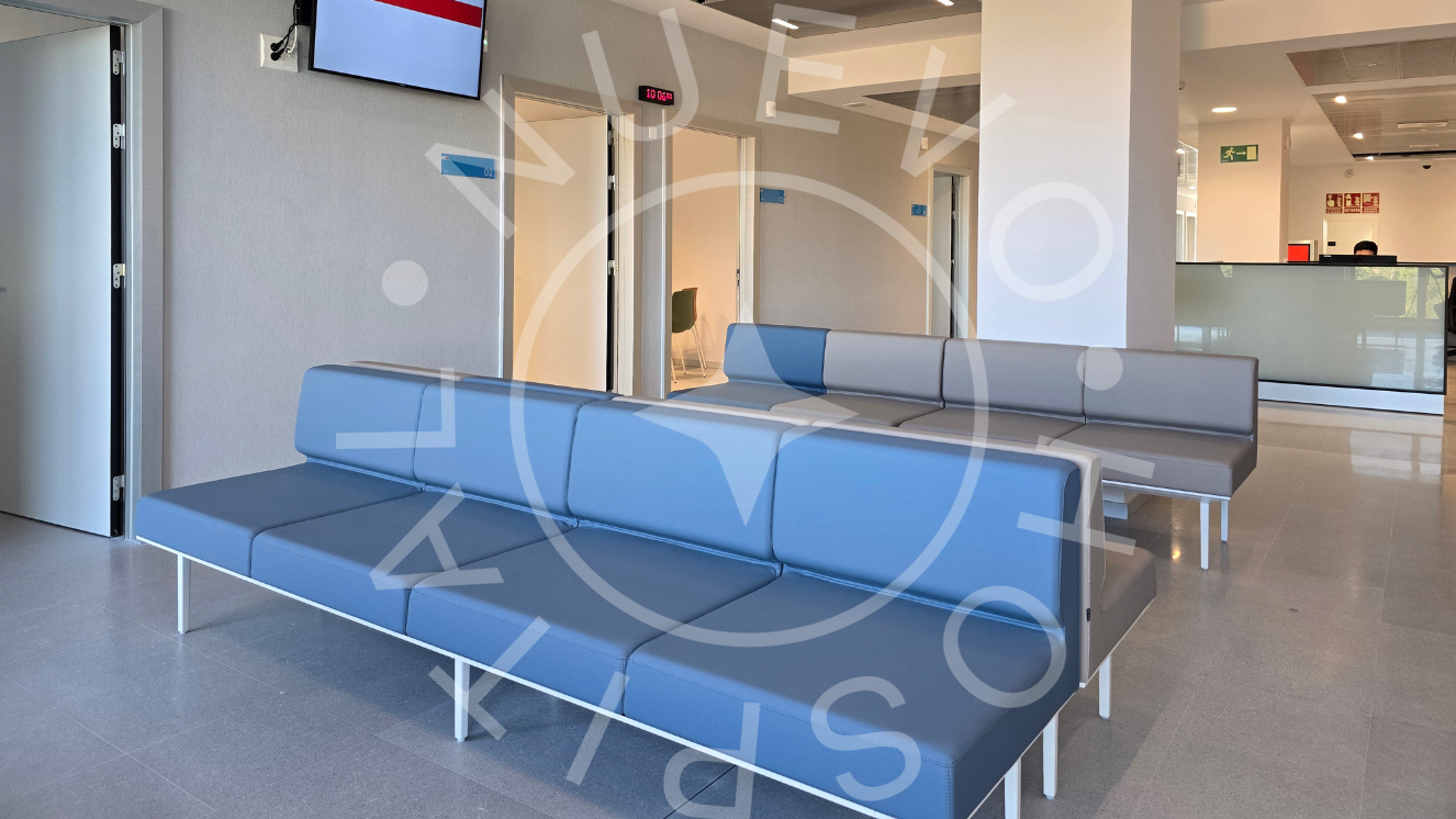 Sillón corrido de sala de espera en color azul primer plano y detrás otros azules y grises