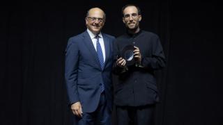 Dos hombres posan uno de ellos con un premio en la mano