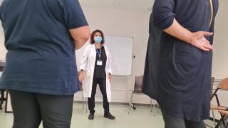 dos mujeres de espaldas en primer plano y en el medio al fondo de frente una doctora