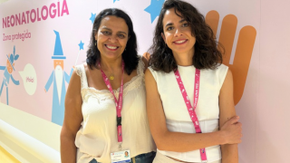 Retrato de dos mujeres de medio cuerpo con mural detrás con dibujos y el texto neonatología