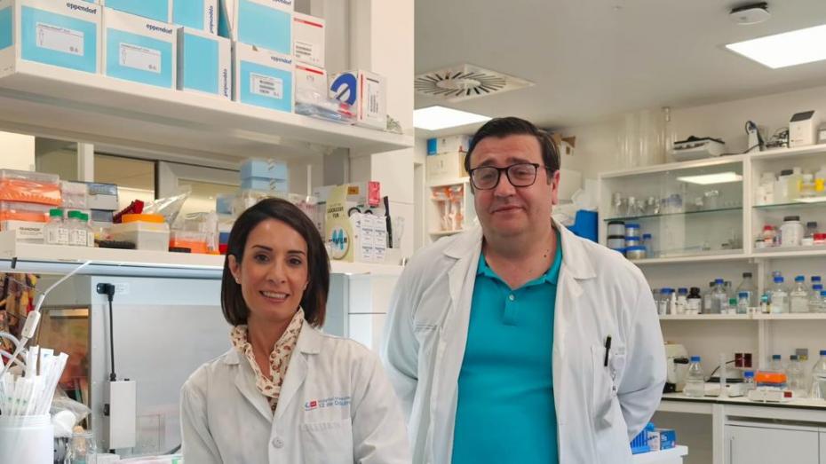 dos profesionales médicos, a la izquierda mujer morena, a la derecha hombre moreno con fondo de laboratorio