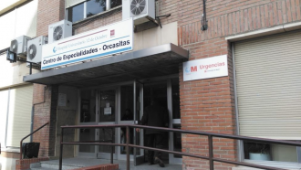 Parte inferior fachada de ladrillo con entrada principal y rótulo oficial de salud