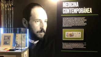 vitrina con sellos a la izquierda  y con fondo de pared de un retrato y un texto