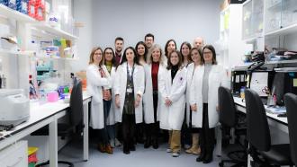 Grupo de médicos posando de frente con laboratoio detrás