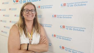 retrato de mujer con melena rubia y brazos cruzados con logos detrás