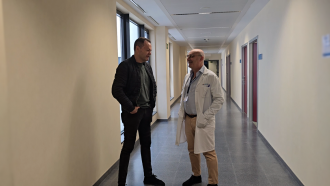 El paciente José Ramón en pasillo charlando con doctor Joaquín Martínez