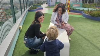 Niño paciente con fibrosis quística en una azotea jardín con dos mujeres