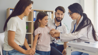 familia con médica que escucha corazón hija