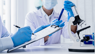 dos profesionales investigando con microscopio