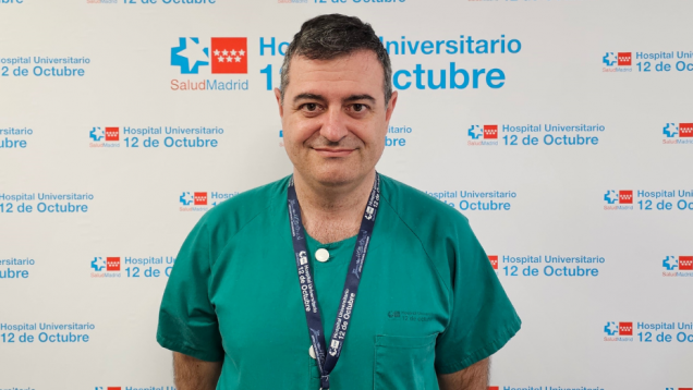 Hombre con pijama verde de sanitario posando primer plano con fondo de panel con logos