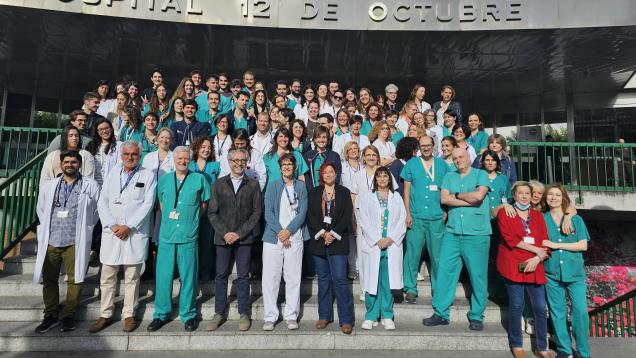 retrato de grupo de profesionales sanitarios con bata blanca o pijama verde, en escaleras