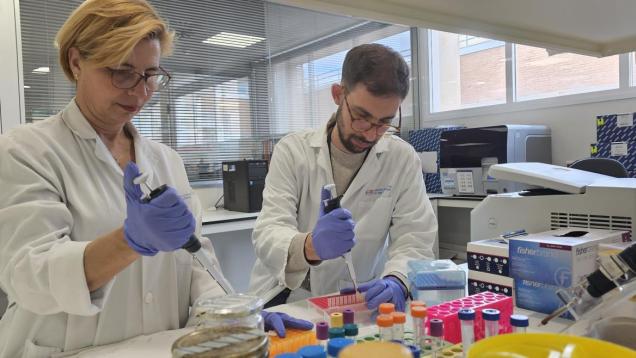 dos investigadores, mujer a la izquierda y hombre a la derecha delante de laboratorios