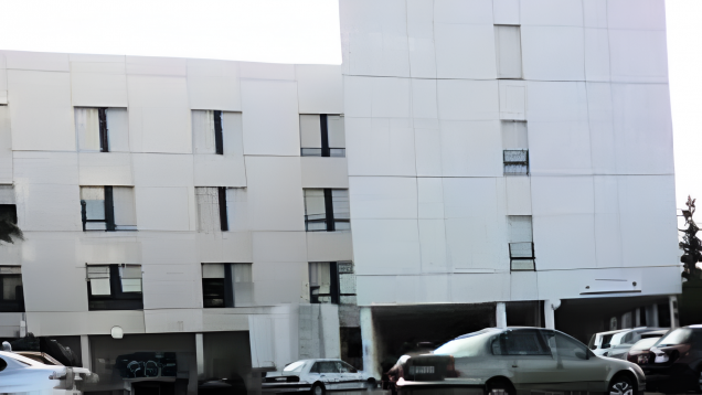 Edificio de frente dos bloques en ele de piedra blanca