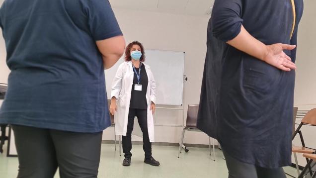 dos mujeres de espaldas en primer plano y en el medio al fondo de frente una doctora
