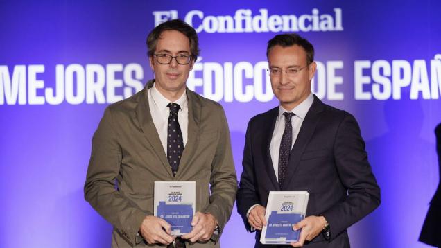 Retrato de dos profesionales con traje y corbata y con premio en la mano, a la izquierda Jorge Solís
