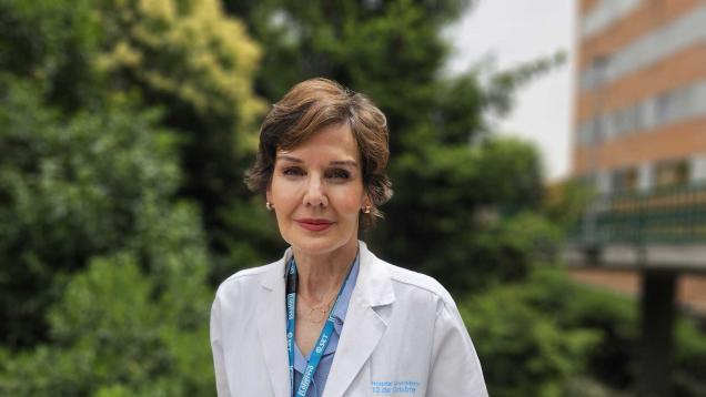 Inmaculada Fernández retrato con bata blanca delante de jardines