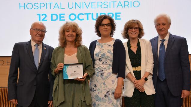 foto de grupo de cinco personas en el medio tres mujeres una de ellas con premio y hombres en las esquinas