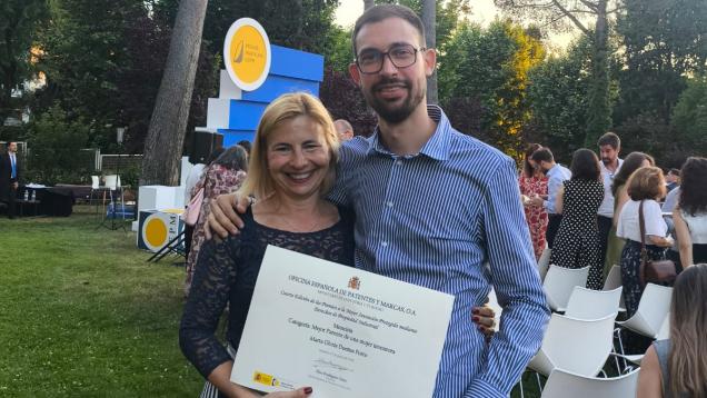 Una mujer y un hombre posando con un diploma en la mano ella