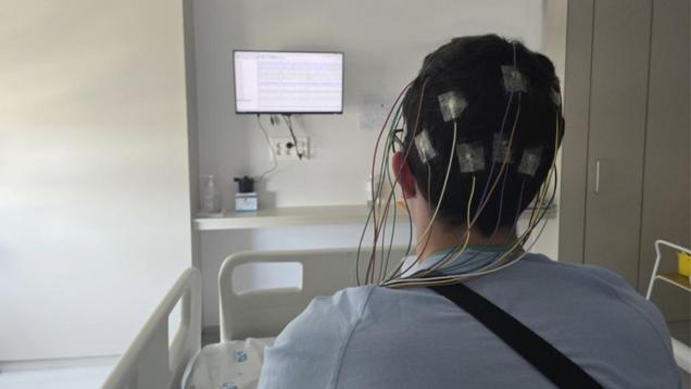 persona de espaldas con ventosas y cables en la cabeza para monitorizar actividad cerebral