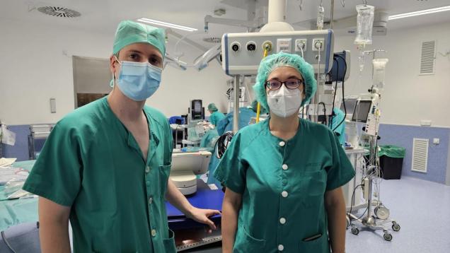 Un neurocirujano y una neurocirujana con mascarillas posando en quirófano con mascarilla