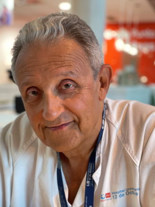 Retrato de médico con bata blanca, pelo canoso y ojos castaños